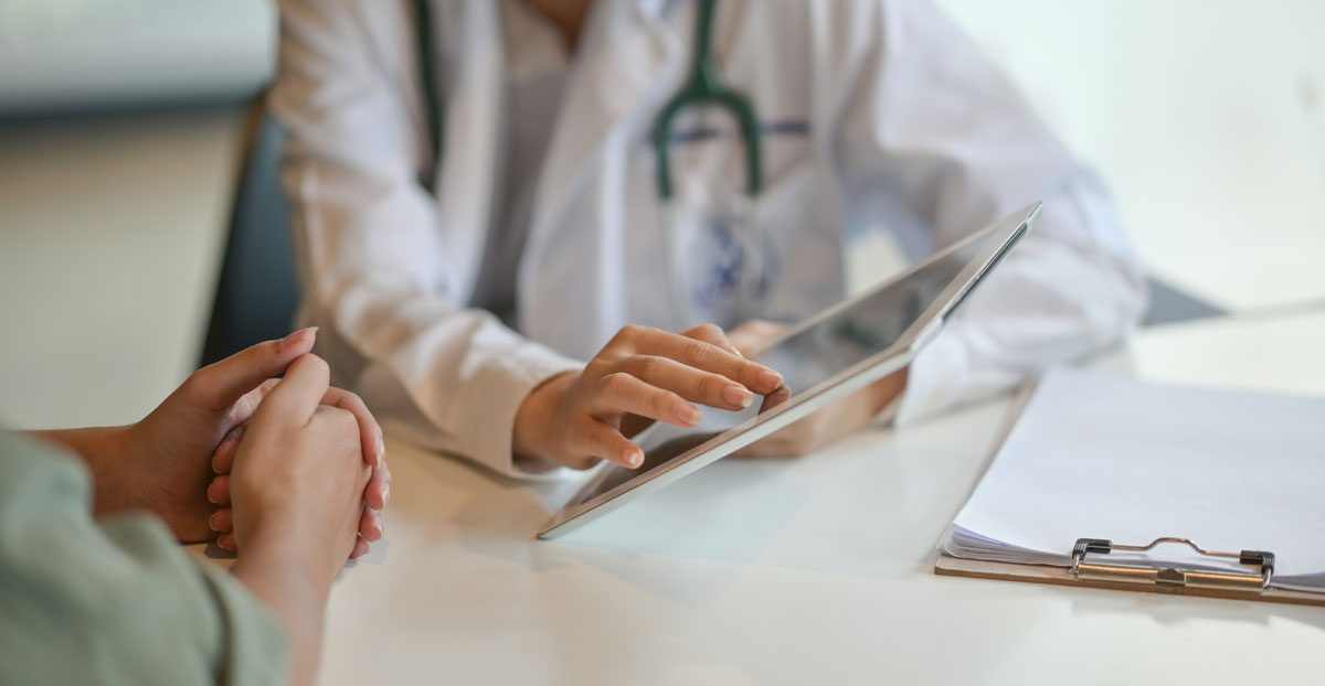 Doctor-discussing-medical-results-with-patient-using-tablet Doctor-discussing-medical-results-with-patient-using-tablet