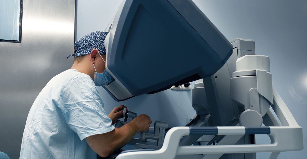 Surgeon-operating-robotic-surgical-system-in-hospital-room Surgeon-operating-robotic-surgical-system-in-hospital-room